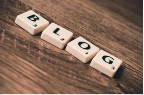 What is a Blog Scrabble letter to form the work Blog on brown desk