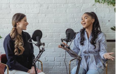 Learn from people with positive mindset Two women talking live with mikes and setup on positive mindset